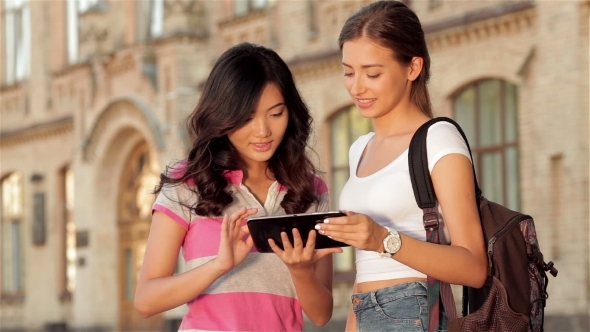 Two Cute Girls Web Surfing On a Tablet alt
