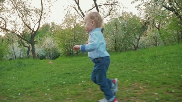 Happy Little Boy Running In Bloomy Park
