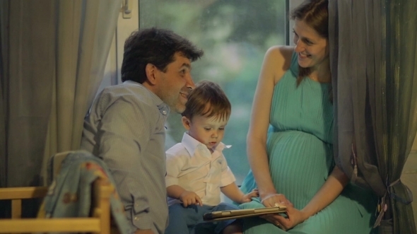 Parents And Child Playing On Touch Pad At Home alt
