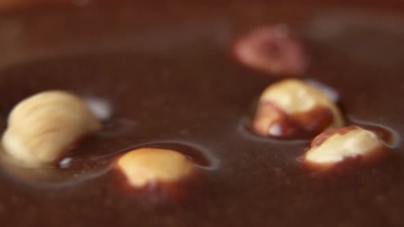 Hazelnuts Fall Into the Chocolate Bath Waves in Slow Motion