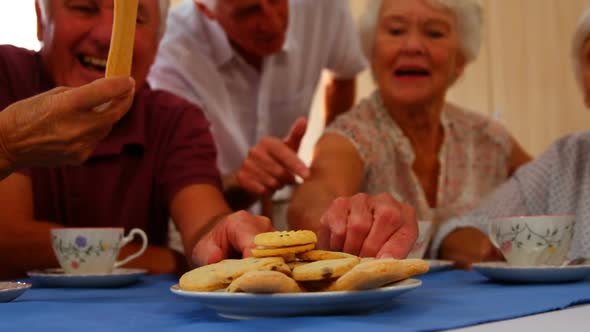 Group of happy senior friends having snacks