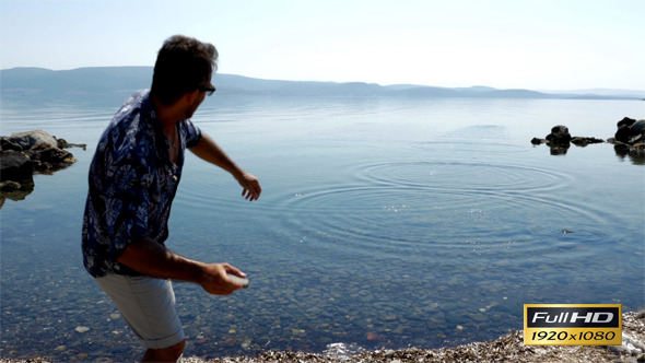 Man Throws Stone To The Sea