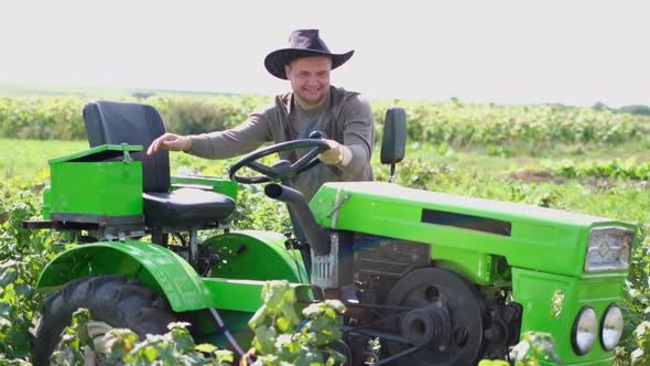 Happy Farmer Sitting Behind a New Twowheeled Tractor