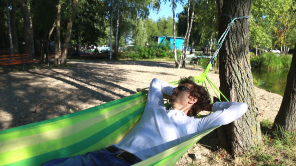  Man Rests in a Hammock on the Beach