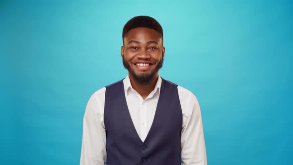 African American Businessman Smiling Against Blue Background