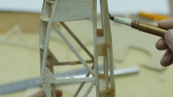 Boy's Hands are Lacquering Billet of Plane Model