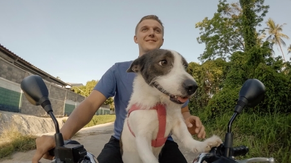 Cheerful Man And Dog Riding The Bike Together