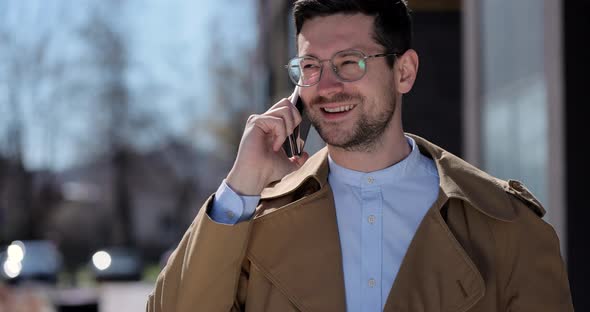 Portrait Handsome Man in Glasses Having Phone Talk on the Street