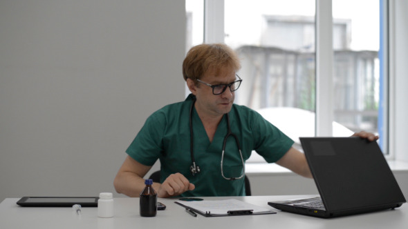 Doctor Completes Work on Laptop and Thinks