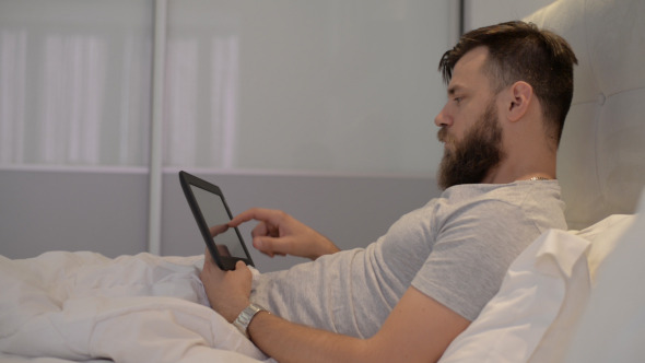 Man Using Tablet in Bed alt
