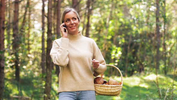 Woman with Mushrooms Calling on Cellphone in Woods