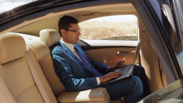 Businessman Working On The Computer In Back Seat