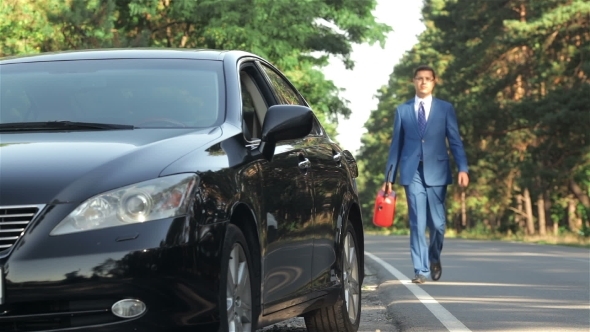 Businessman On The Road With a Jerrycan alt
