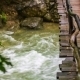 Man Walking On Bridge Hanging Above Rough River - VideoHive Item for Sale