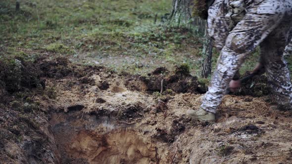 One Soldier Digs a Trench in a Pine Forest