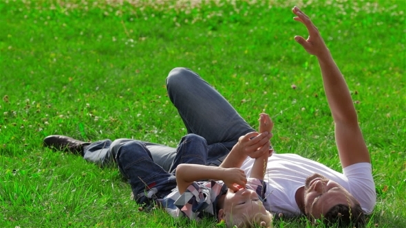 Father And Son Dreaming On The Grass In Park alt