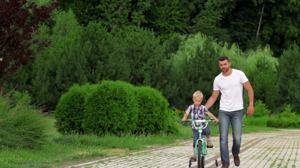 Father Teaching His Son To Ride a Bike alt