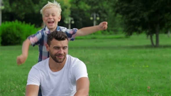 Father And Son Playing In Park alt