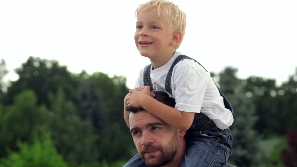 Happy Father With His Baby Son On His Neck alt