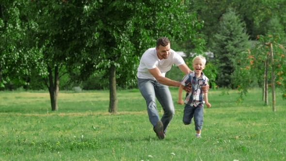 Happy Father And Son Playing Outdoors