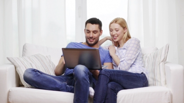 Happy Couple With Laptop Computer At Home