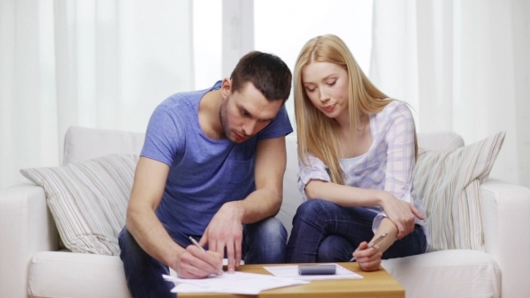 Busy Couple With Papers And Calculator At Home