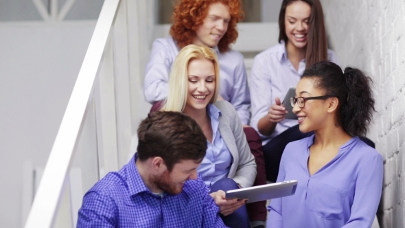 Team With Tablet Pc Computers Sitting On Staircase