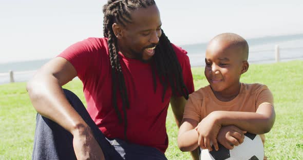 Video of happy african american father and son having fun outdoors