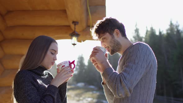 Young couple drinking from Christmas mugs