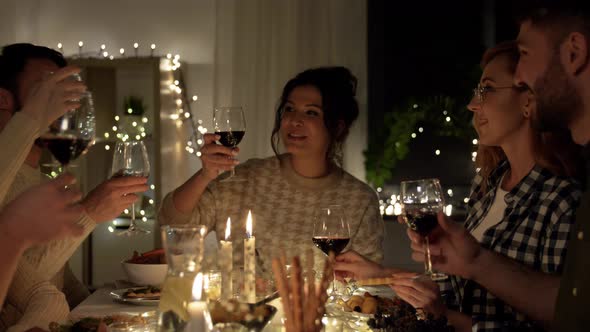 Happy Friends Drinking Red Wine at Christmas Party