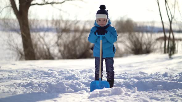 Little Boy Shoveling Snow at Winter