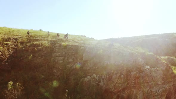 Tourists Joyfully Running Towards Each Other Near Rocky Cliff in Prairie in Slowmotion