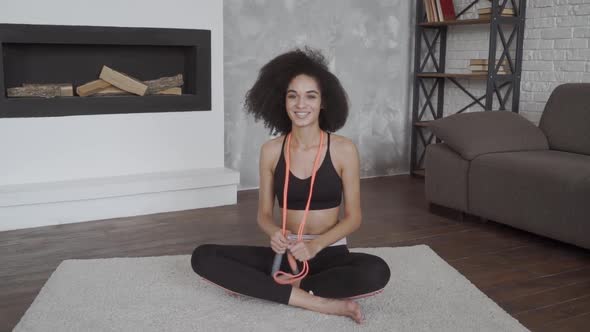 Sportive Young Cheerful African American Lady Working Out on a Rug.