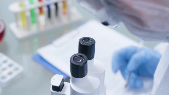 Male Scientist Working in the Lab, Looking Into the Microscope