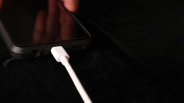 Man disconnects smartphone from charging plug in the charger USB