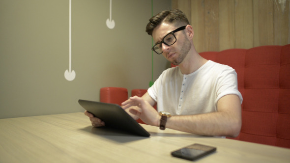 Man Typing on Tablet