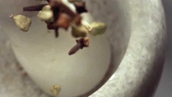 Granite Mortar and Cardamom and Cloves Spice Species Falling in Slow Motion