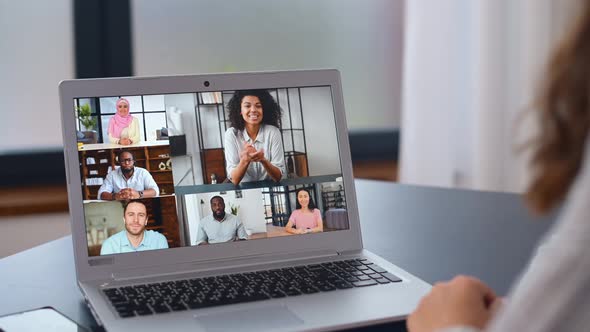 Young Woman Using a Laptop for Video Connection with Diverse Group of People