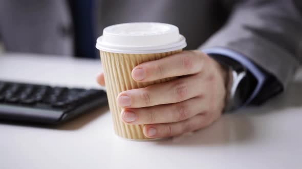 Close Up Of Businessman Hand With Coffee Paper Cup