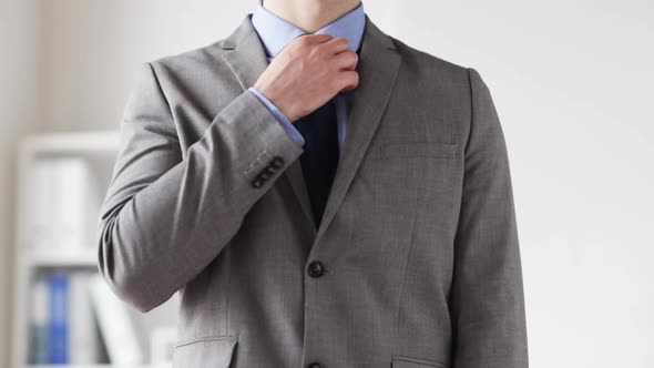 Close Up Of Man In Suit Adjusting Necktie 1 alt