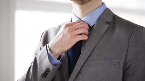 Close Up Of Man In Suit Adjusting Necktie 2