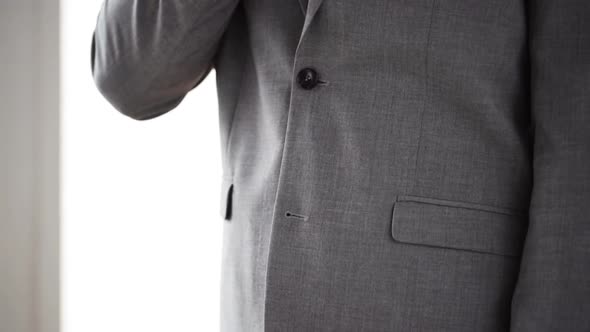 Close Up Of Man In Suit Fastening Button On Jacket 2