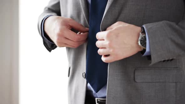 Close Up Of Man In Suit Fastening Button On Jacket 3 alt