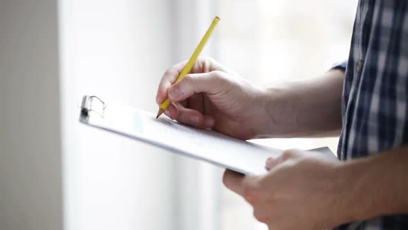 Close Up Of Man Looking And Writing To Clipboard 4