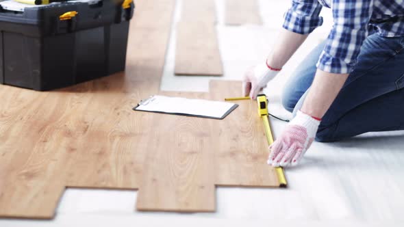 Close Up Of Man Measuring Flooring And Writing 1