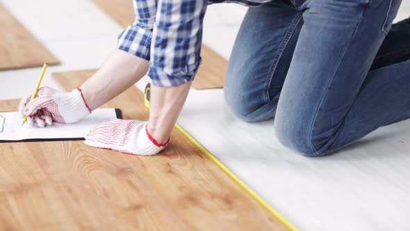 Close Up Of Man Measuring Flooring And Writing 2