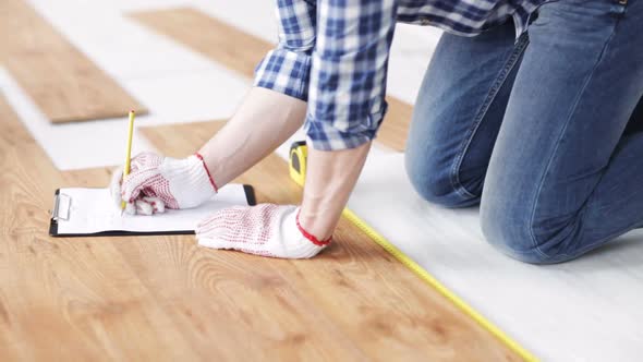 Close Up Of Man Measuring Flooring And Writing 3