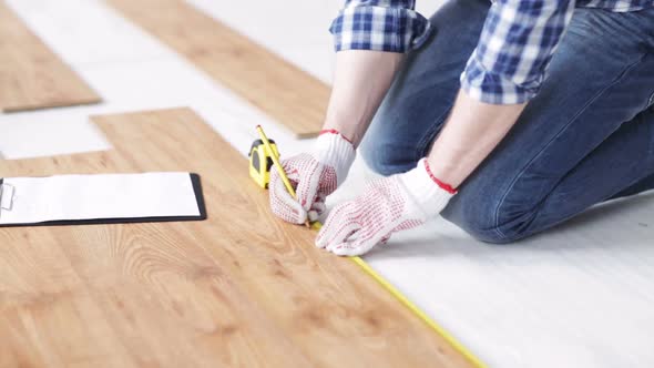 Close Up Of Man Measuring Flooring And Writing 4