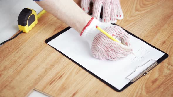Close Up Of Man Measuring Flooring And Writing 6