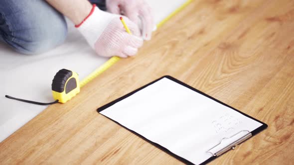 Close Up Of Man Measuring Flooring And Writing 7